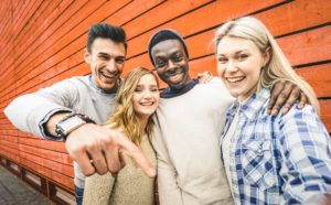 Happy multiracial friends group taking selfie with mobile smart phone